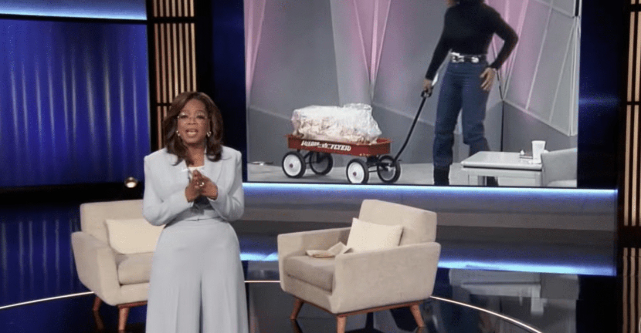 Oprah standing in front of a television set